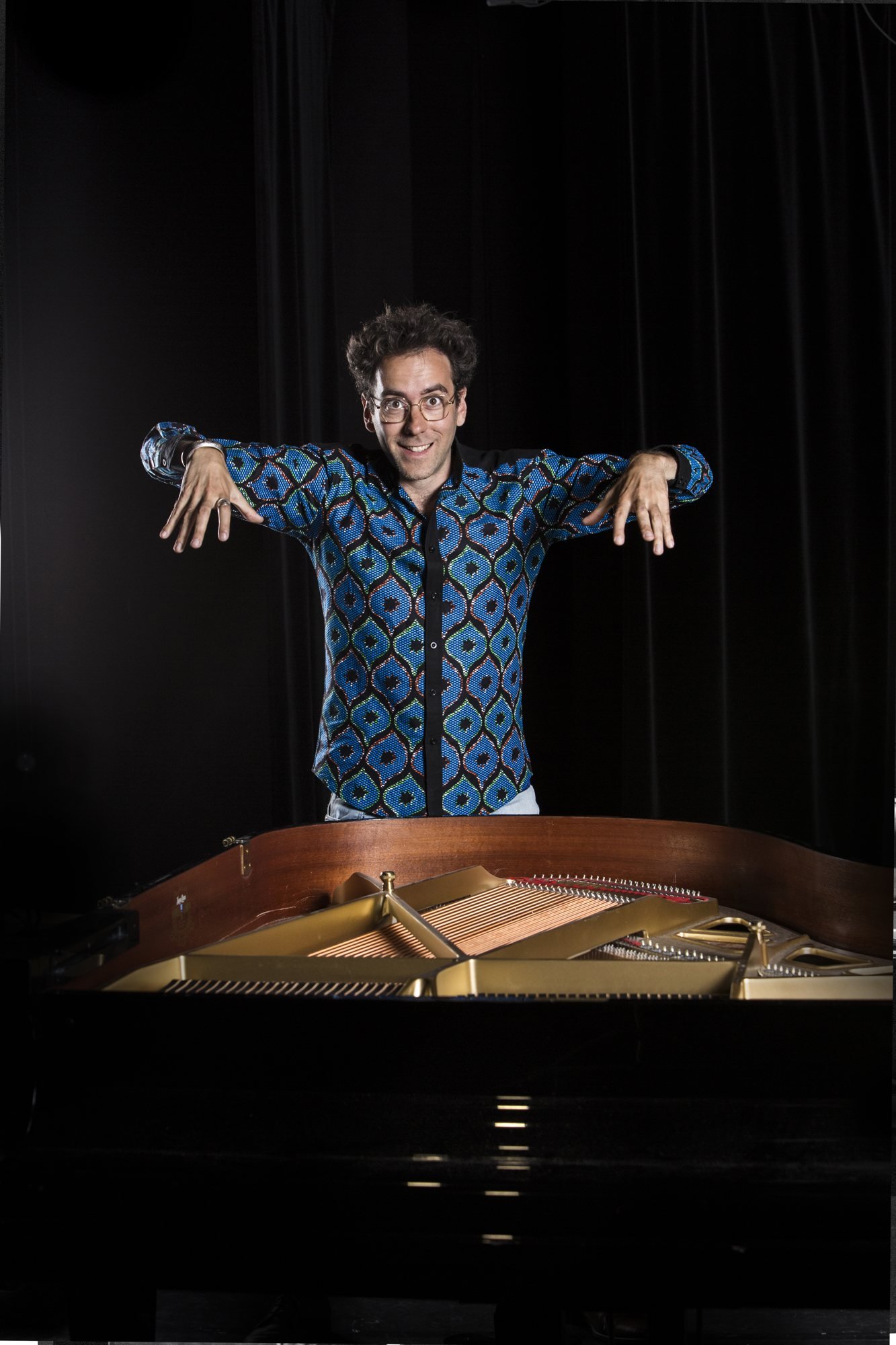 Dexter Goldberg, les mains tendues au-dessus d'un piano à queue ouvert
